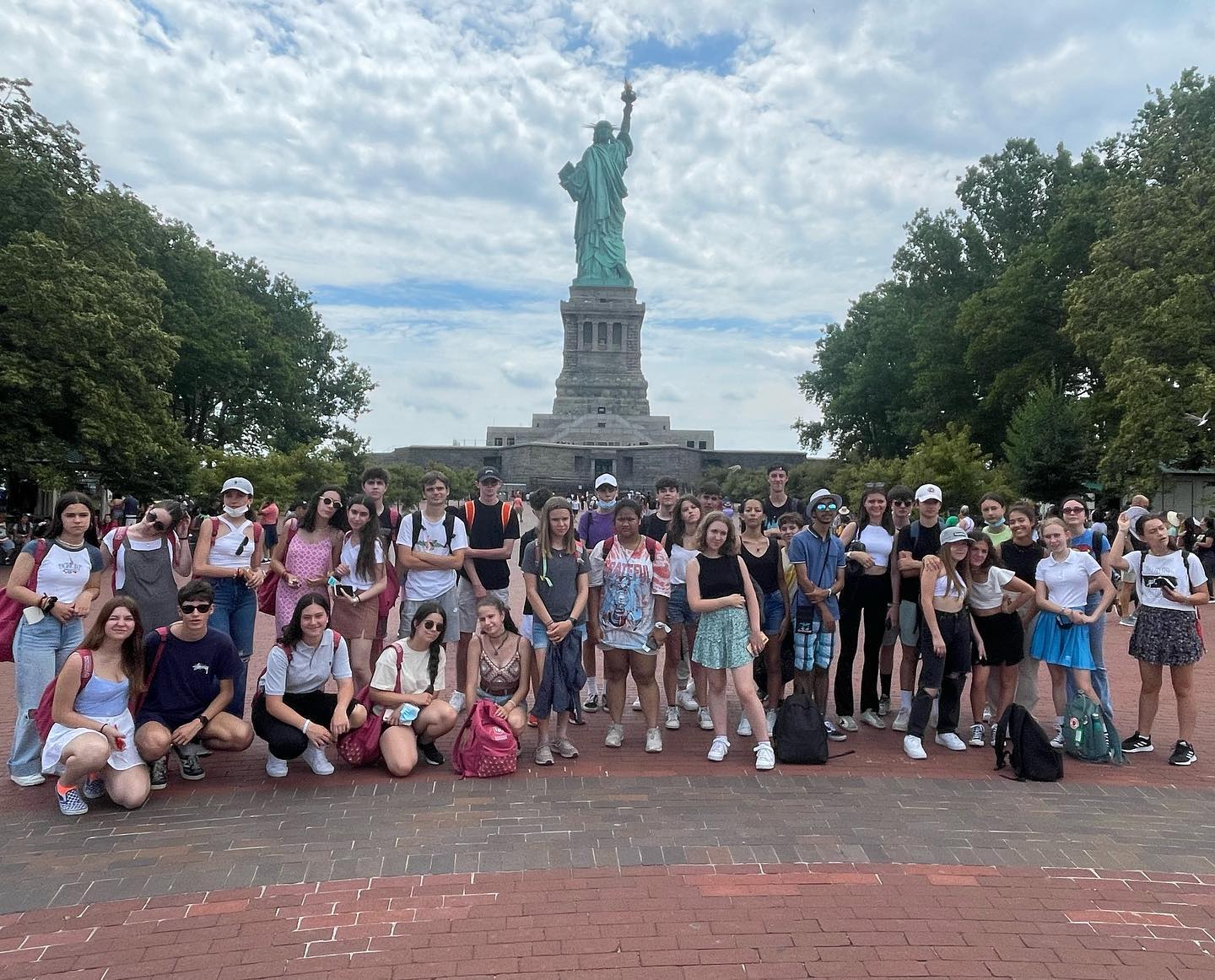 A group of students in front of the Statue of Liberty