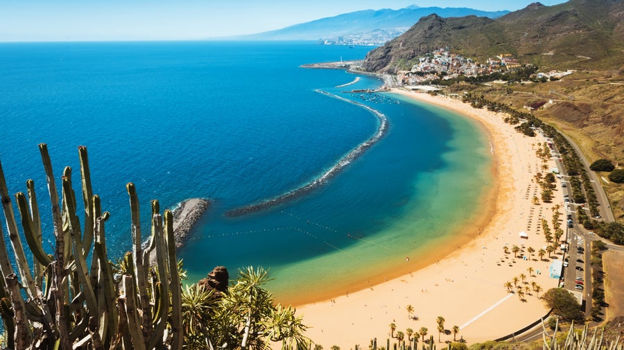 Aerial view of Playa de Las Teresitas beach in Tenerife, Spain, with the Anaga Mountains in the background and golden sandy shore