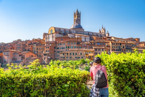 Tourist taking a photo of Siena Historic buidlings in Italy