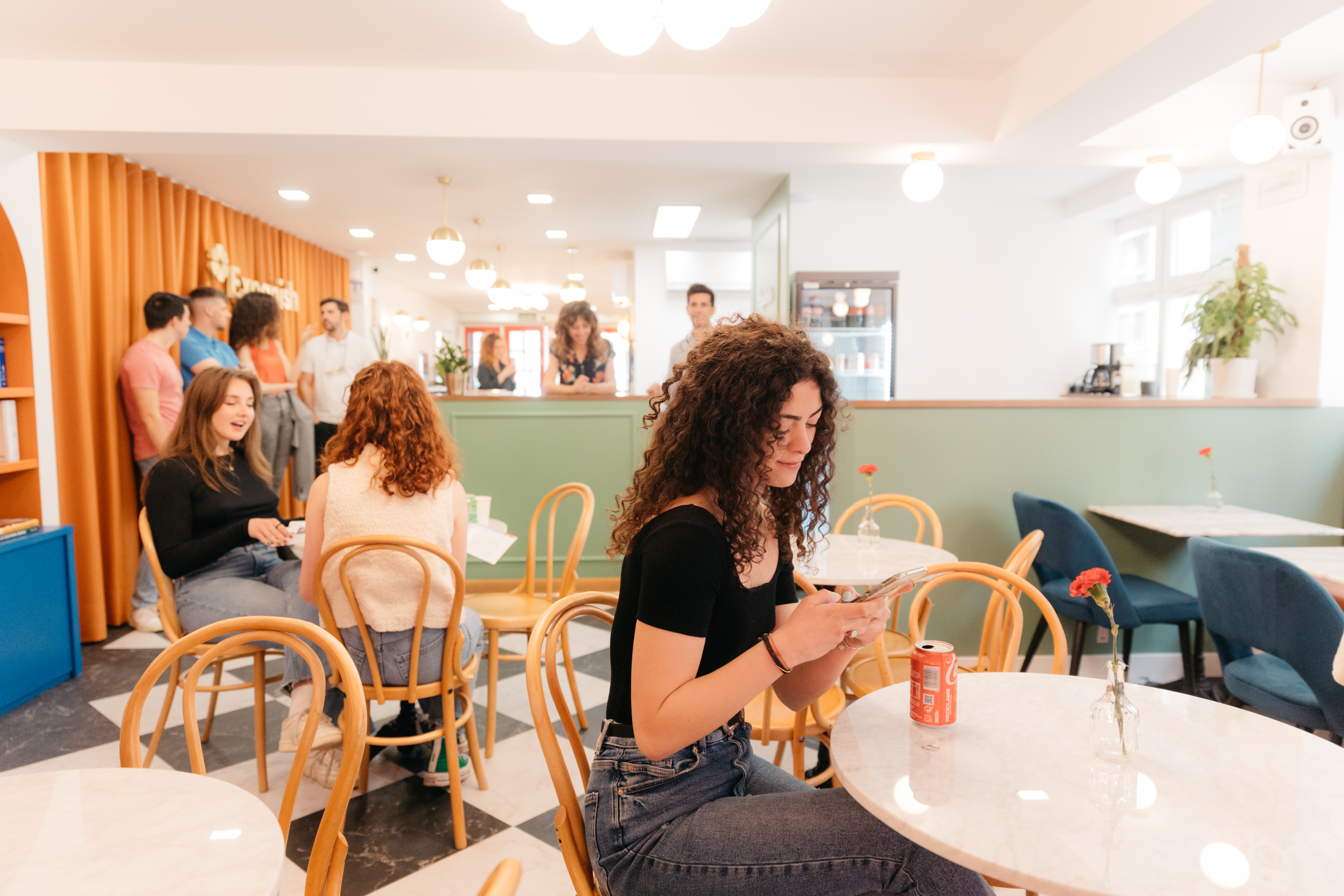 A student looking at her phone in the common area