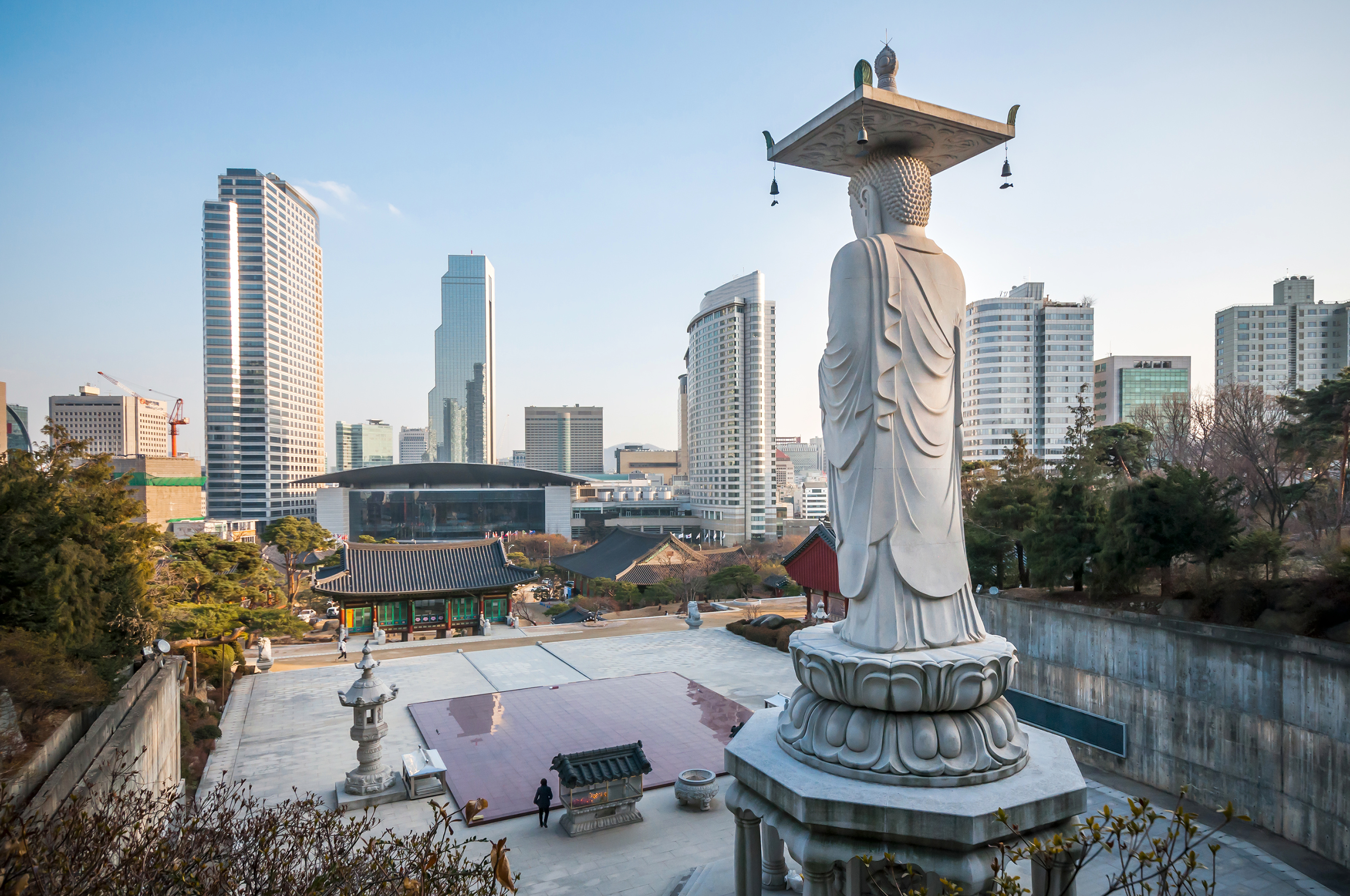 Bongeunsa Temple in Seoul, Korea, with traditional pavilions, Maitreya Buddha statue, and modern skyscrapers in the background