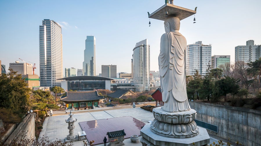 Bongeunsa Temple in Seoul, Korea, with traditional pavilions, Maitreya Buddha statue, and modern skyscrapers in the background