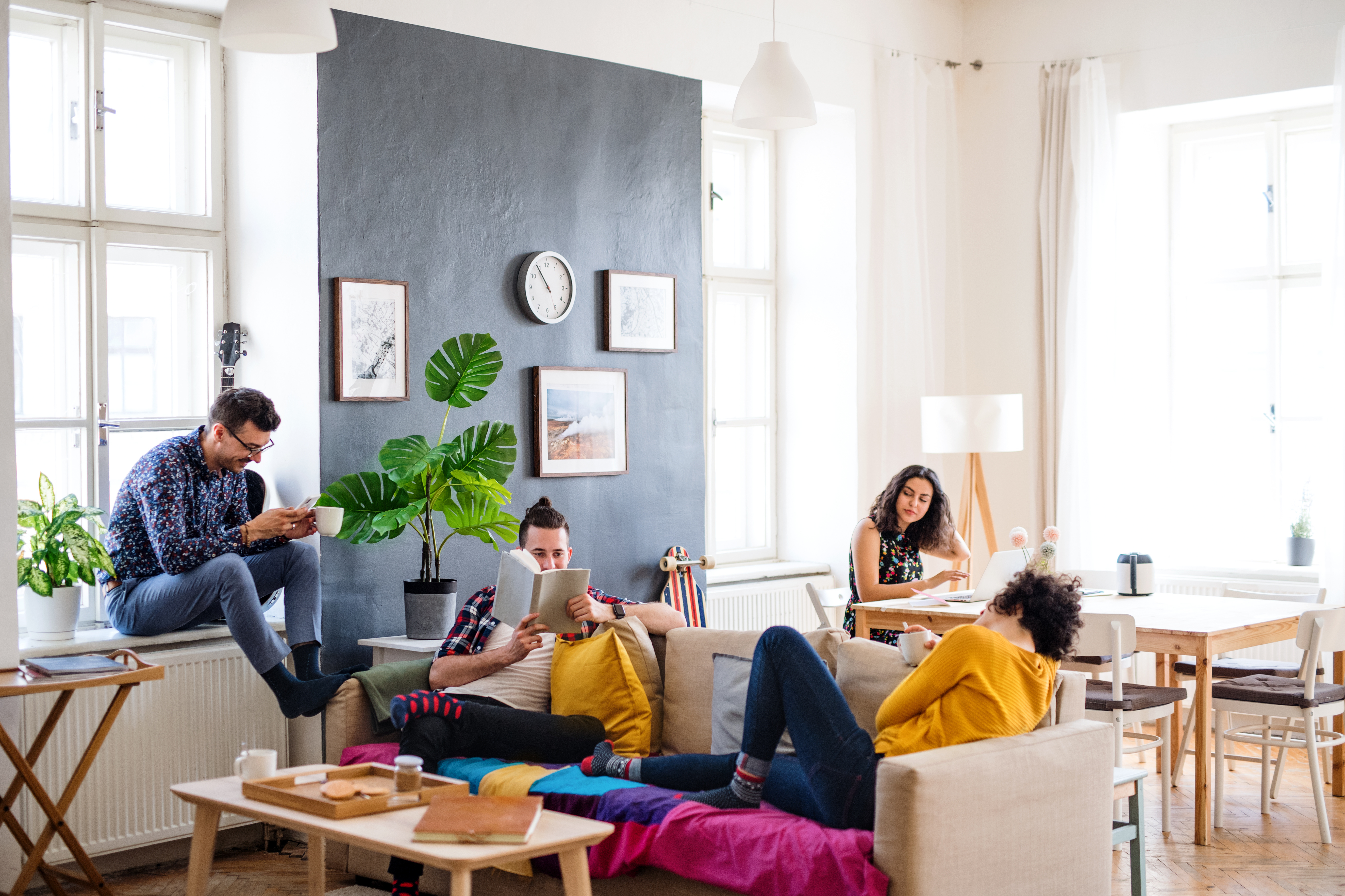 Group of young friends relaxing indoors, representing a house-sharing lifestyle concept