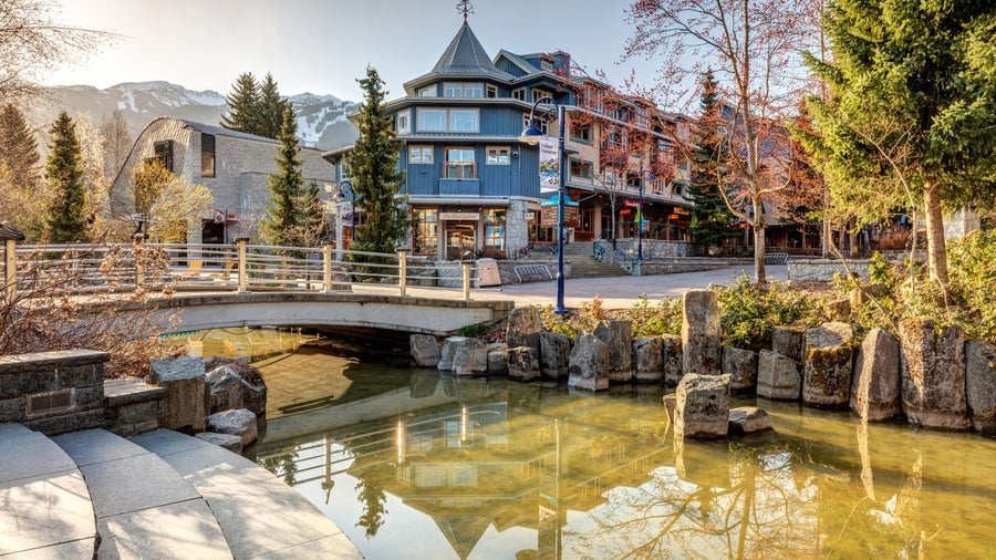 Whistler Village city center in Whistler, Canada, with alpine-style buildings and nearby Lost Lake surrounded by forested mountains