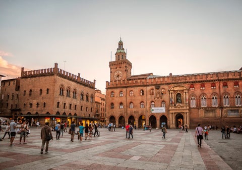 Piazza Maggiore in Bologna with its expansive historic square, surrounded by architectural landmarks like the Basilica of San Petronio, the Palazzo d'Accursio