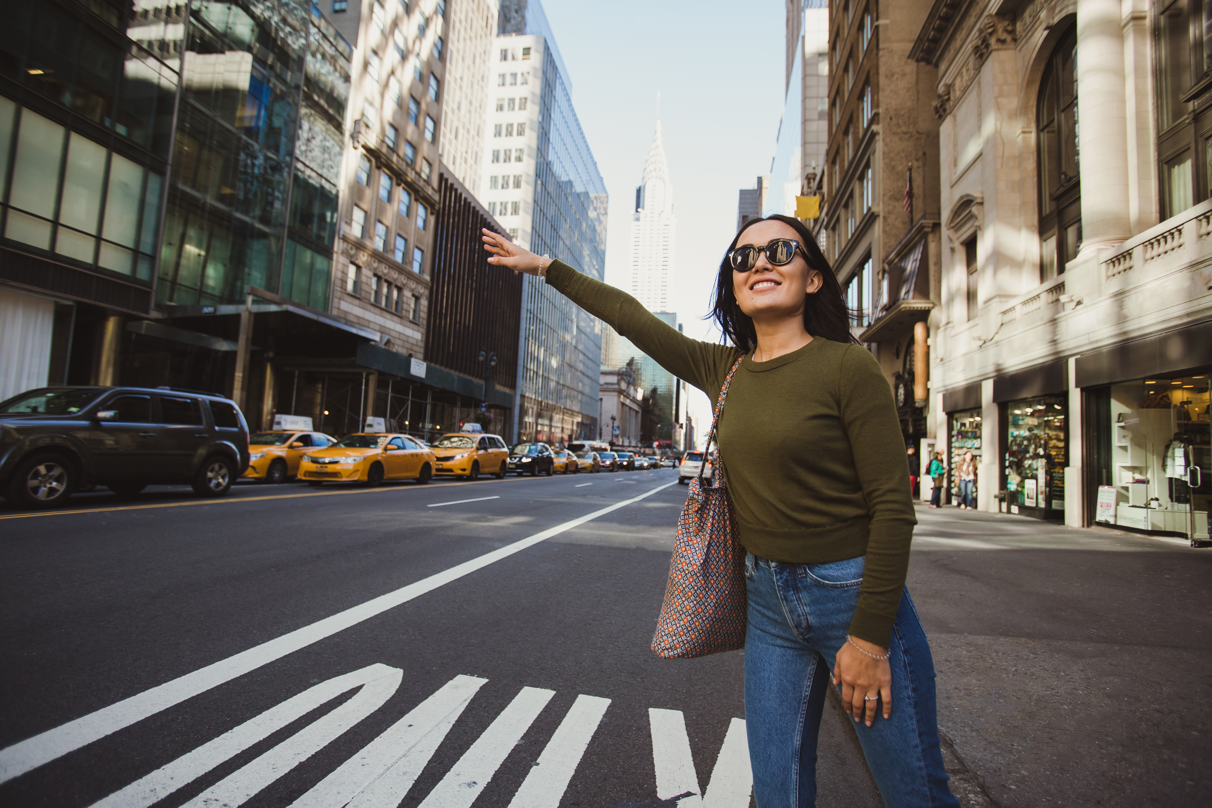 Girl tourist calling a cab on the streets of Manhattan, New York City