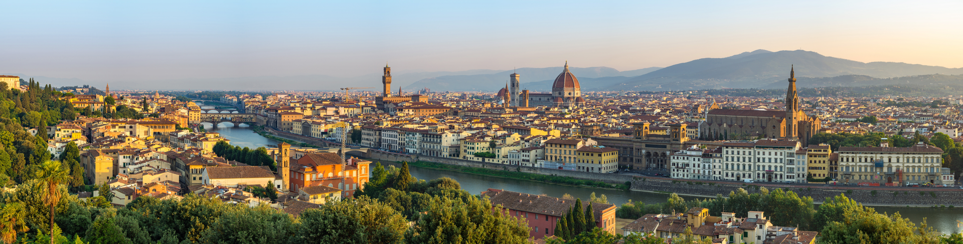 Aerial view of Florence featuring the historic Ponte Vecchio with its iconic medieval bridge spanning the Arno River