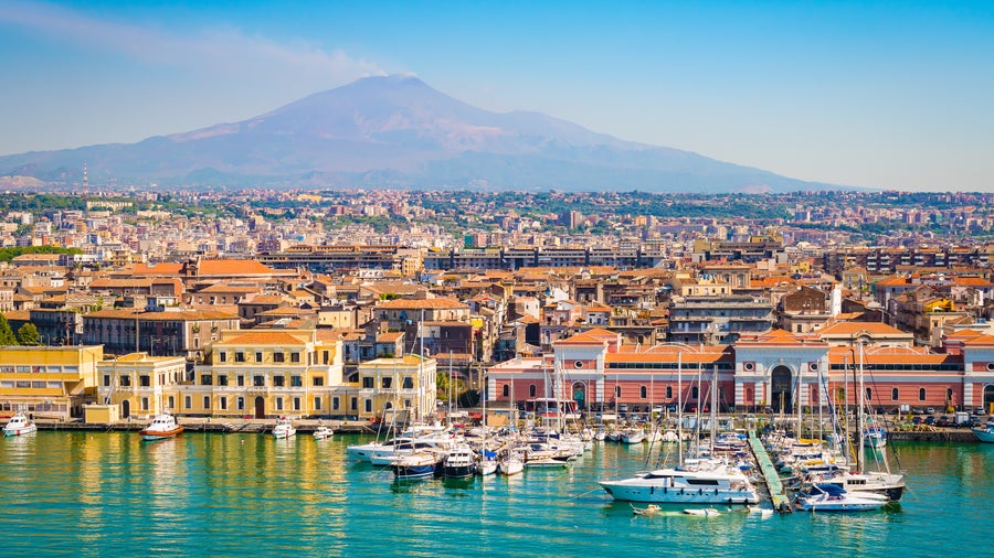 Boats in the Harbour of Catania, Italy, with the Mount Etna in the background