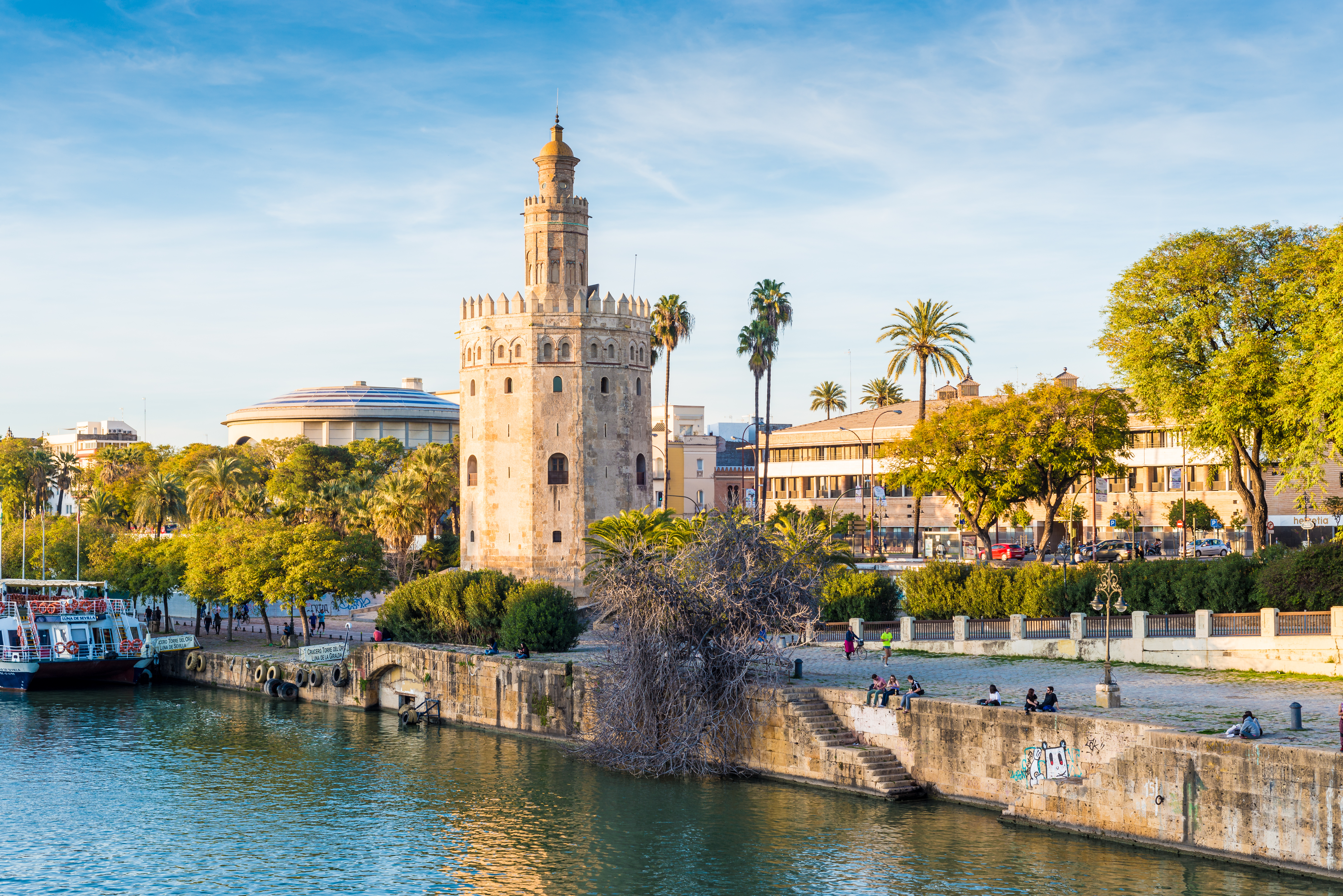 Torre del Oro tower in Seville, Spain, with its golden medieval walls reflecting sunlight along the Guadalquivir River