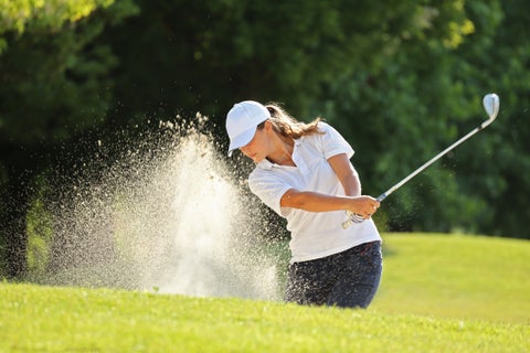 Woman playing golf on a lush green golf course in Cologne, Germany