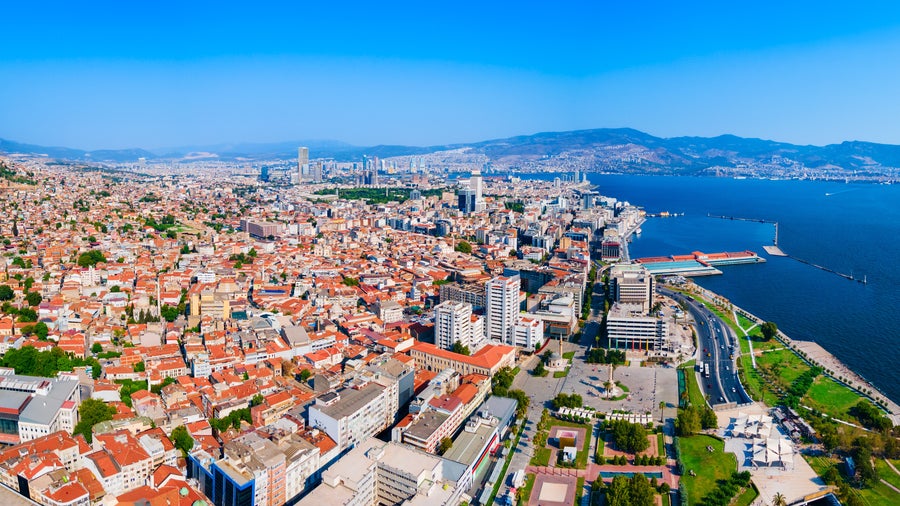 Aerial view of Izmir, Turkey, showing modern cityscape along the Aegean Sea shoreline with the historic Asansör Elevator, Konak Square, and Clock Tower