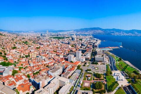 Aerial view of Izmir, Turkey, showing modern cityscape along the Aegean Sea shoreline with the historic Asansör Elevator, Konak Square, and Clock Tower