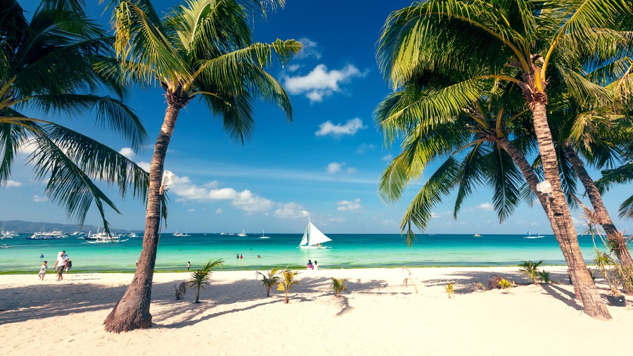 Pristine white sandy beach with clear turquoise waters at Boracay Island, Philippines