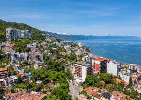 "Aerial view of Amapas in Puerto Vallarta, Mexico, showing upscale villas and condos nestled between green hills and the blue waters of Banderas Bay