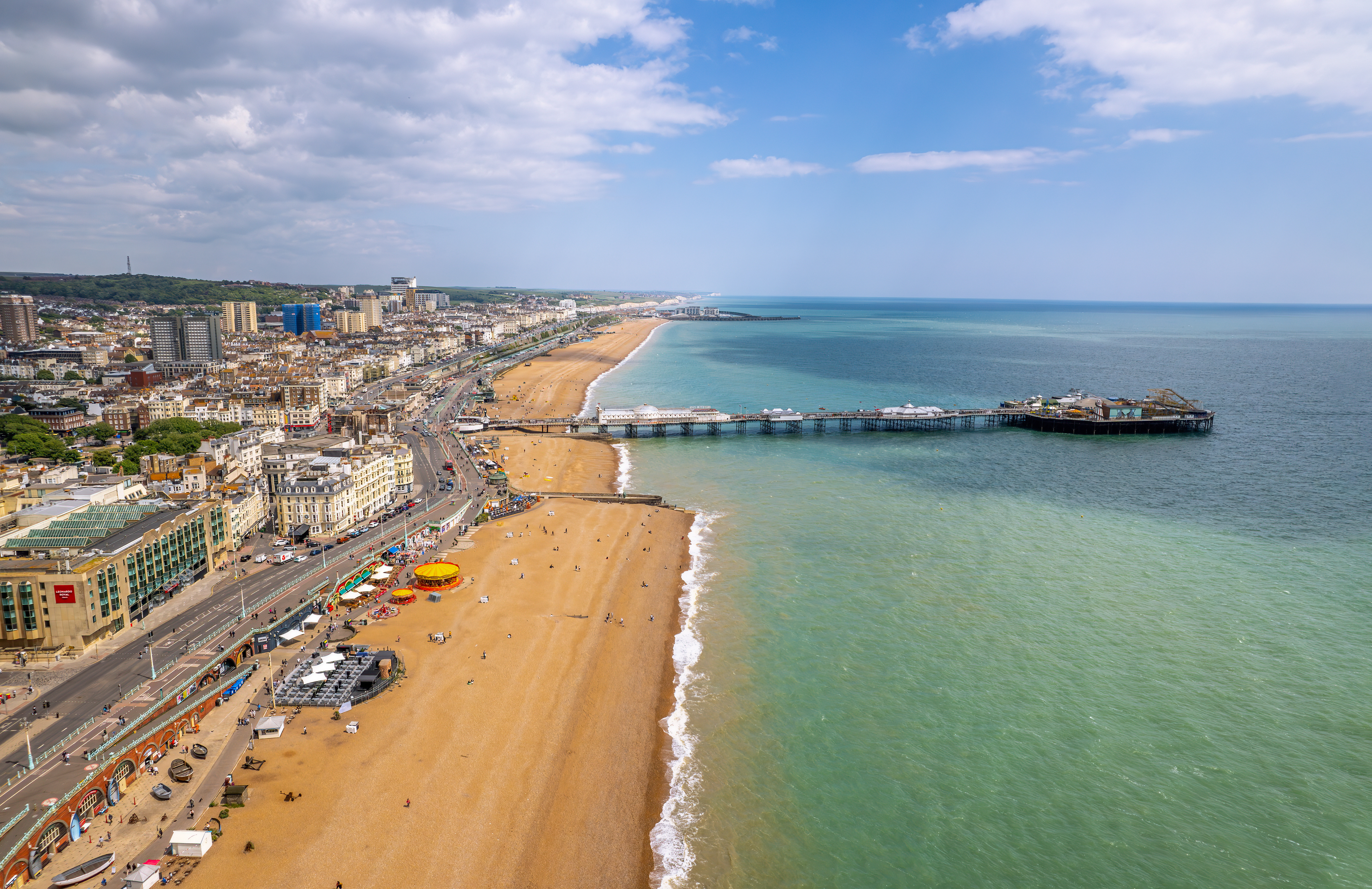 Aerial drone view of Brighton Palace Pier and Brighton Beach, England, highlighting the city center and seaside attractions