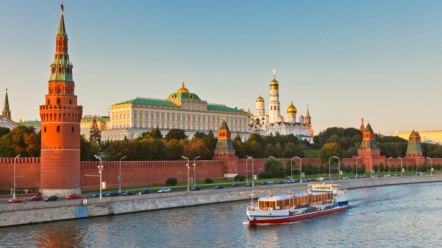 The Moscow Kremlin overlooking the Moskva River with a boat passing by