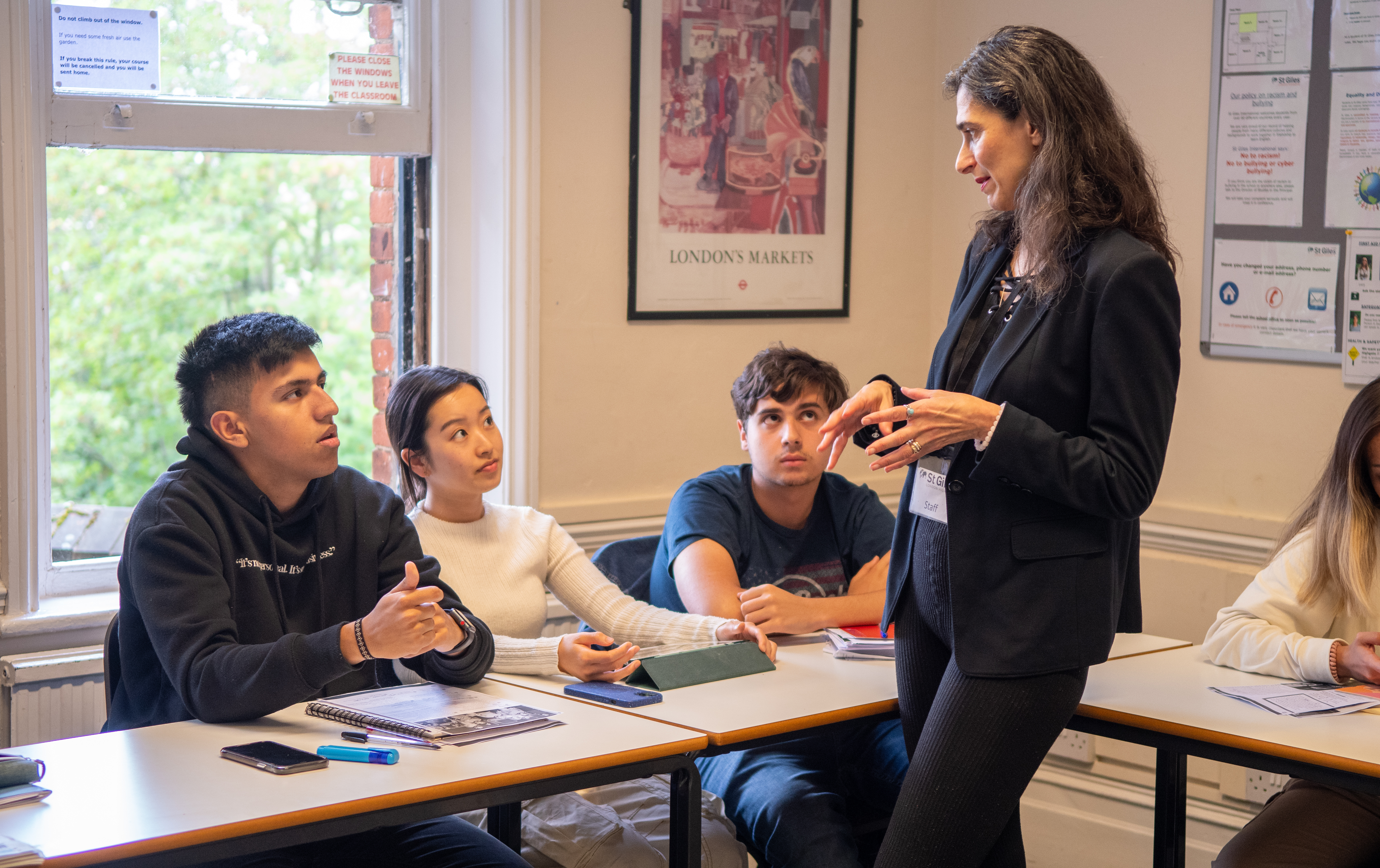 A teacher explaining a lesson to her students at London Highgate College Programme