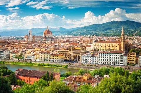 Aerial view of Florence with its Cathedral (Duomo) surrounded by terracotta rooftops, medieval towers, and Renaissance landmarks