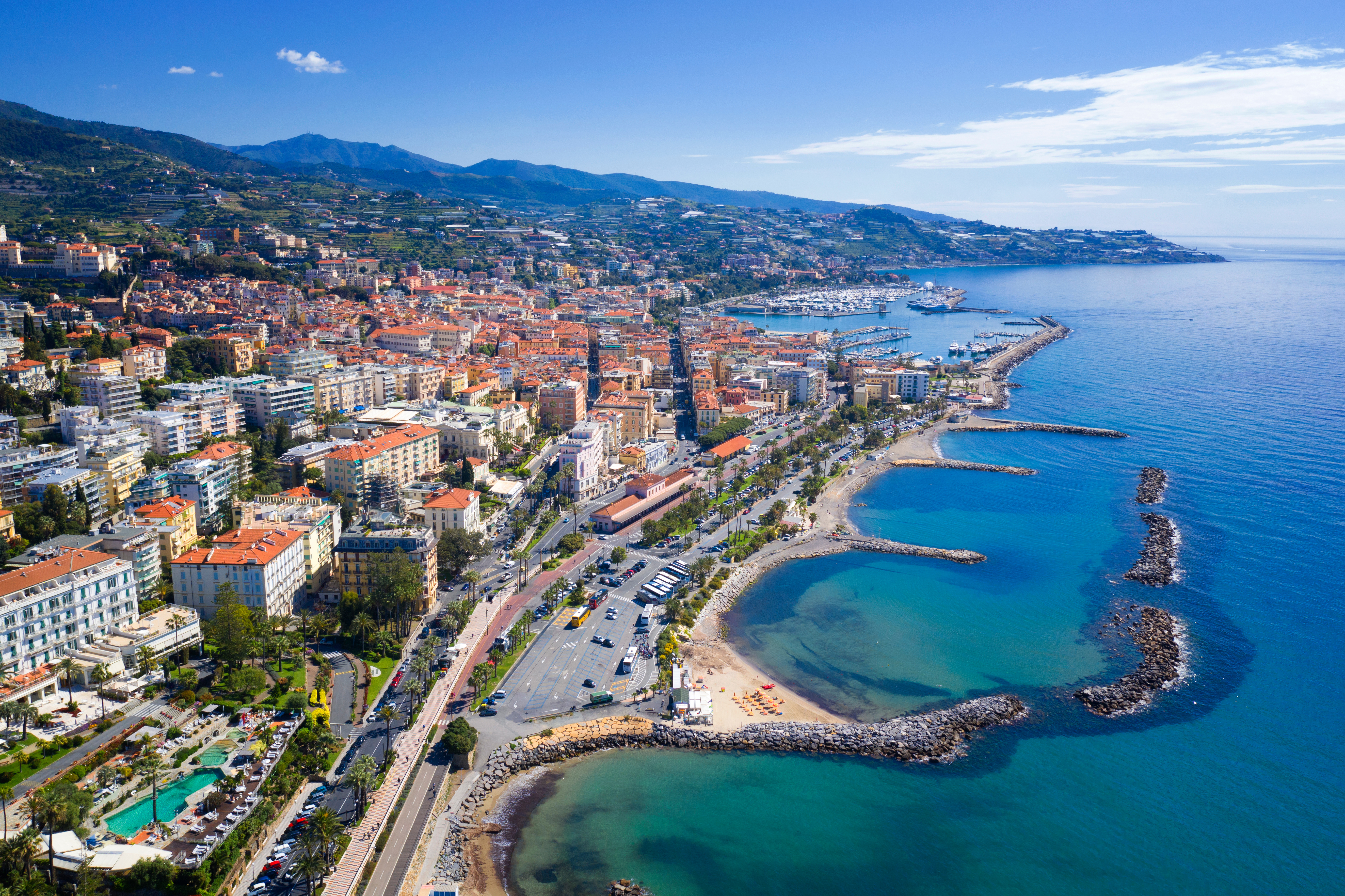 Aerial view of Sanremo, Italy, showing the coastline, hillside buildings, and Mediterranean Sea