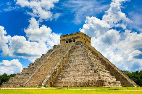 Chichén Itzá featuring the iconic El Castillo pyramid (Temple of Kukulcán) surrounded by lush greenery and ancient Maya ruins near Playa Del Carmen, Mexico