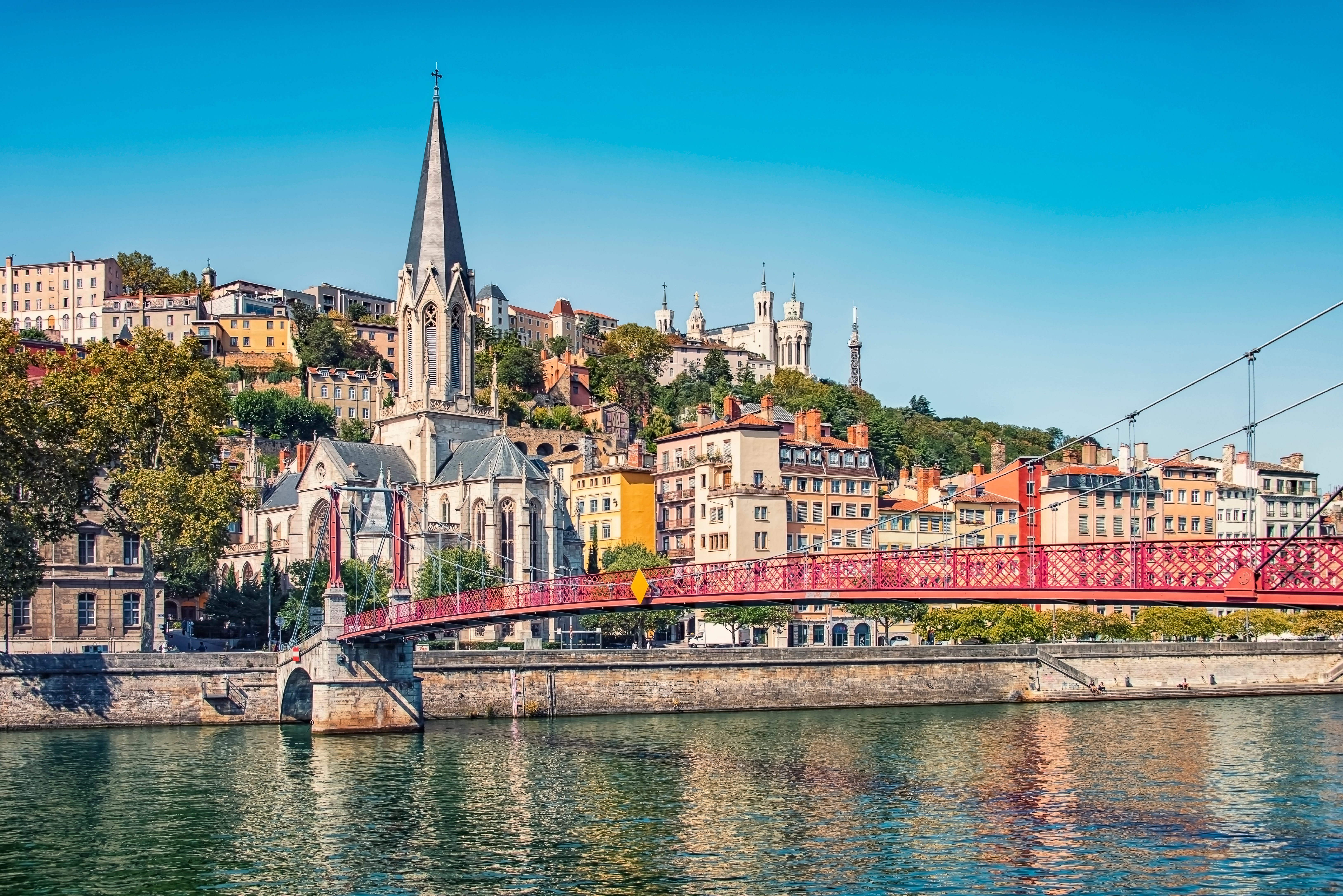Passerelle Saint-Georges, suspension bridge spans the Saône River, connecting the Vieux Lyon (Old Town) district to the Presqu'île with Église Saint-Georges in the background