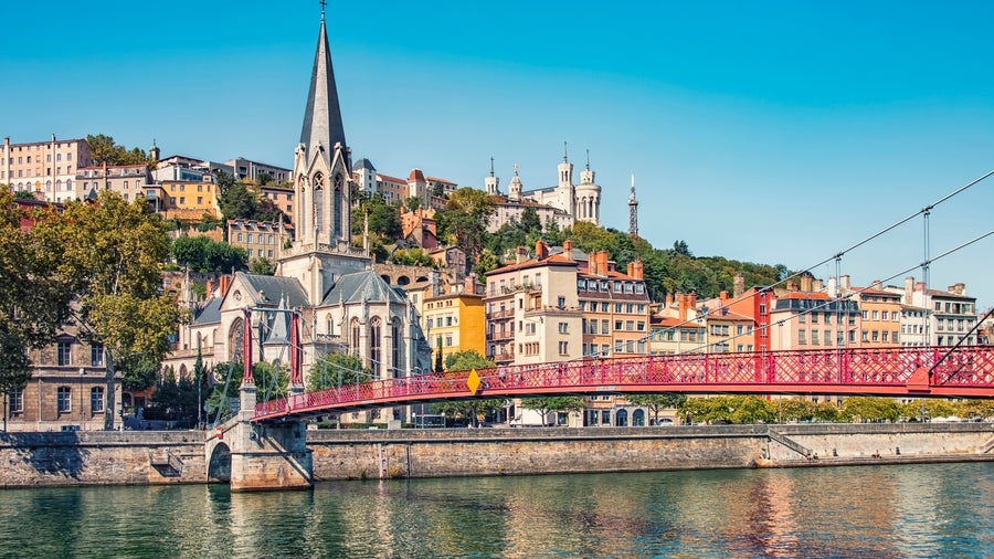 Passerelle Saint-Georges, suspension bridge spans the Saône River, connecting the Vieux Lyon (Old Town) district to the Presqu'île with Église Saint-Georges in the background