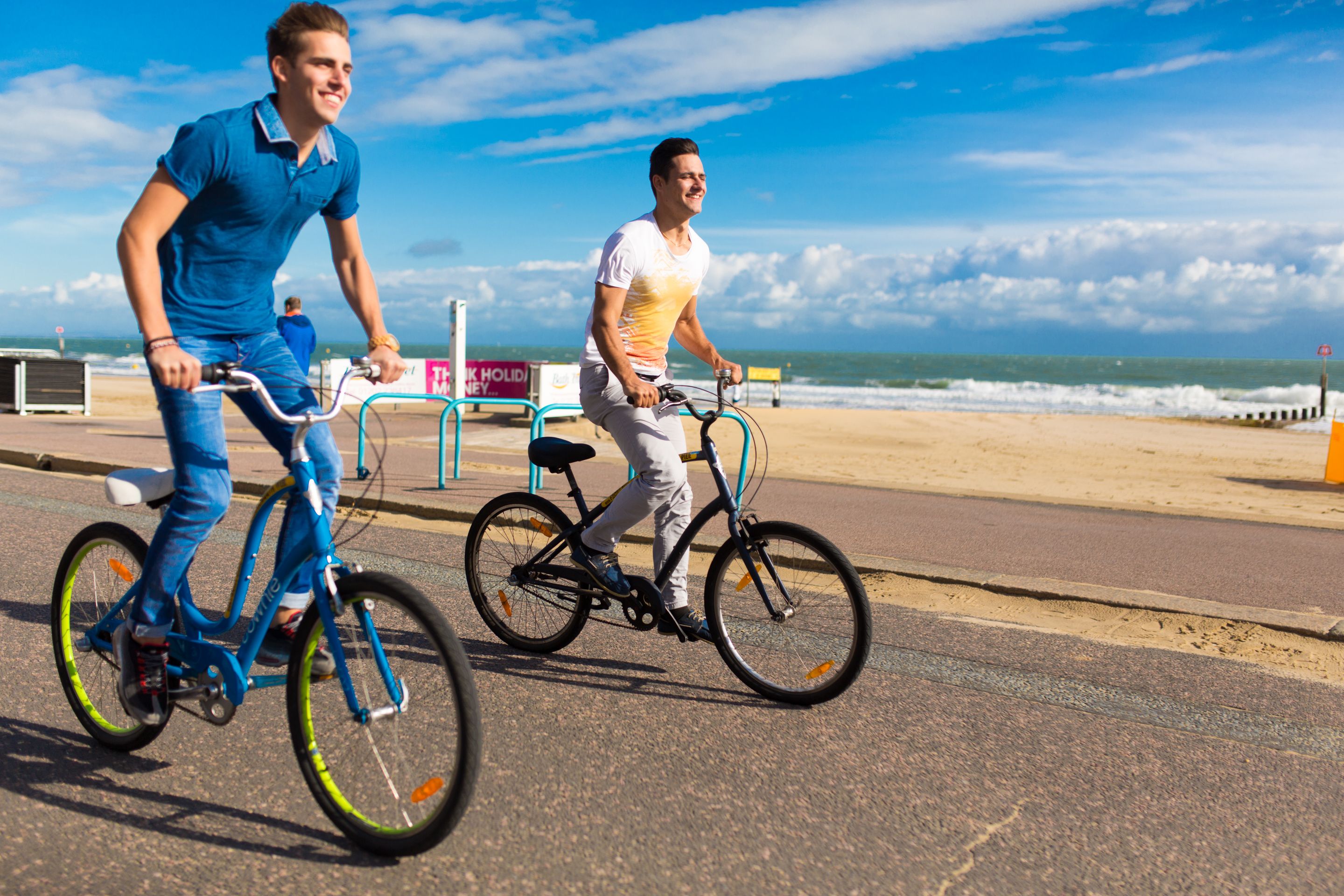 two students riding a bike on seafront at bournemouth