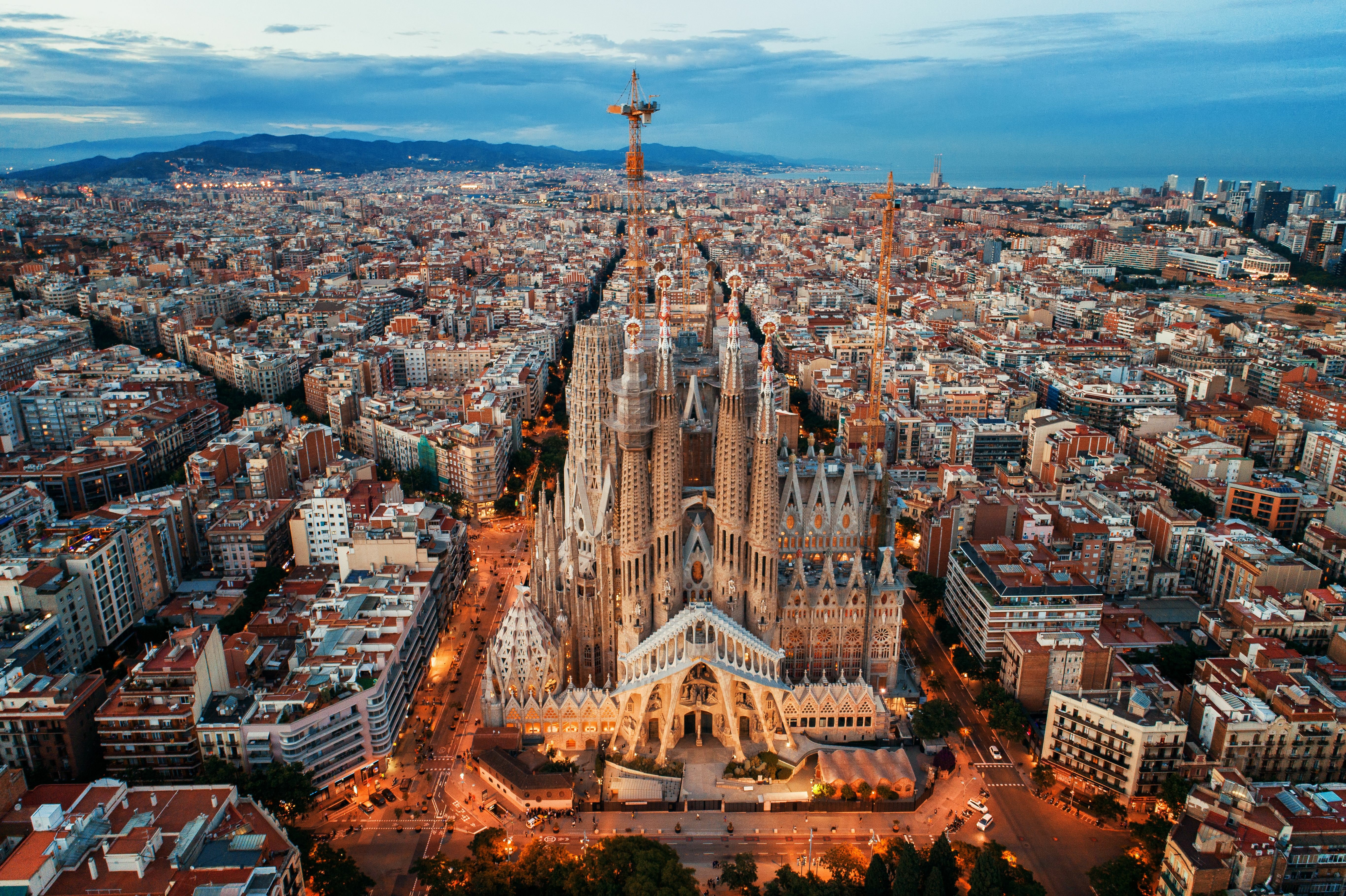 Aerial view of the Sagrada Familia in Barcelona, Spain, highlighting its intricate architecture and towering spires amidst the vibrant cityscape