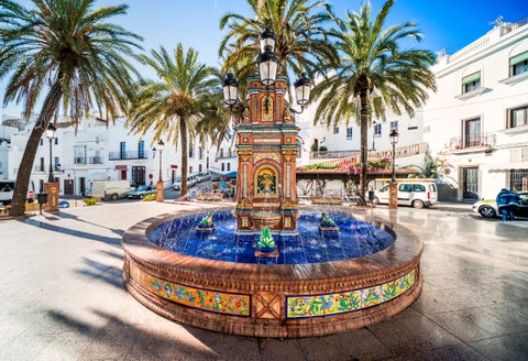 Colourful illuminated fountain at Plaza de San Juan de Dios in Cádiz, Spain, with historic buildings in the background