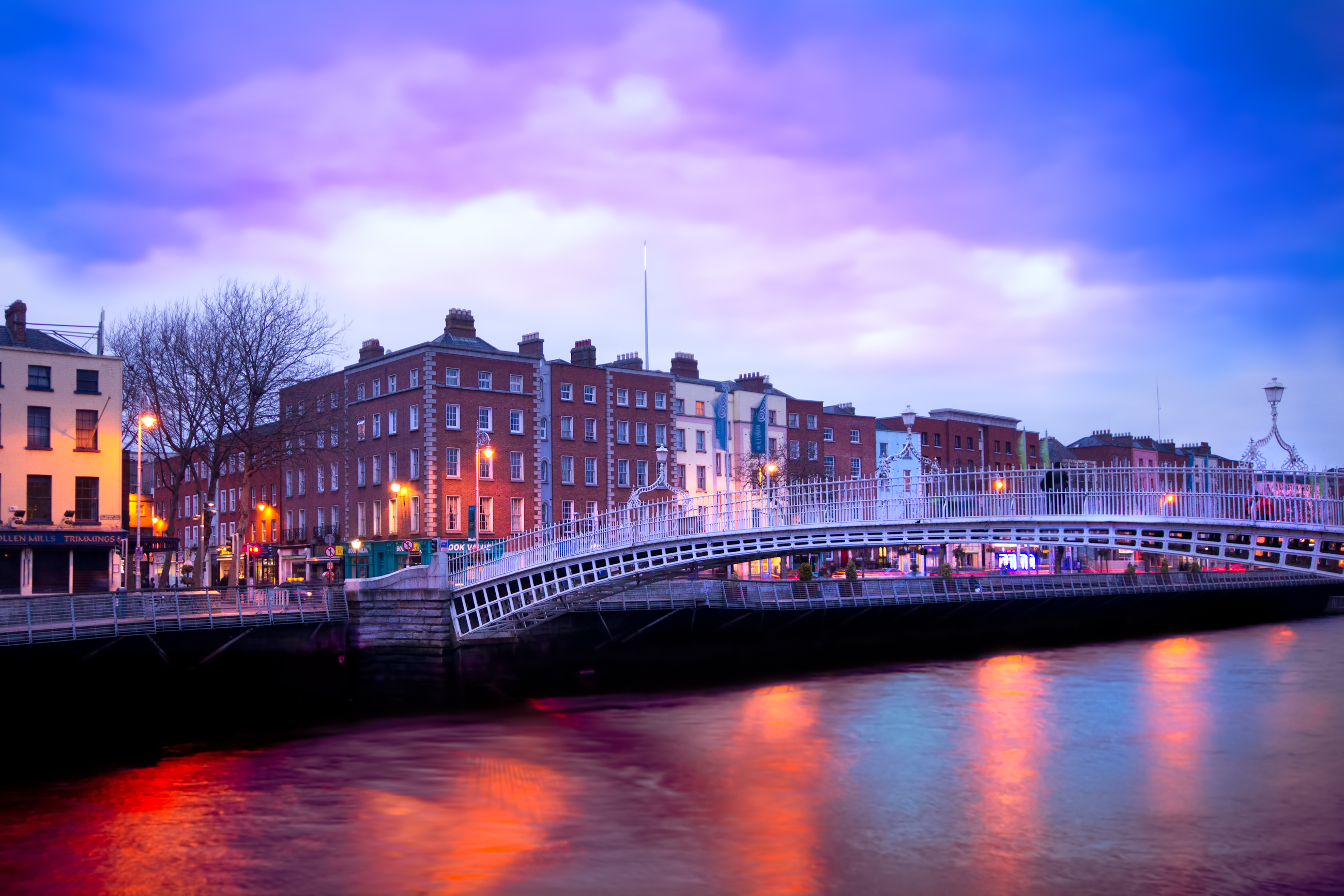Pink sky sunset over Dublin, Ireland, with traditional houses along the river and an iconic bridge spanning the water
