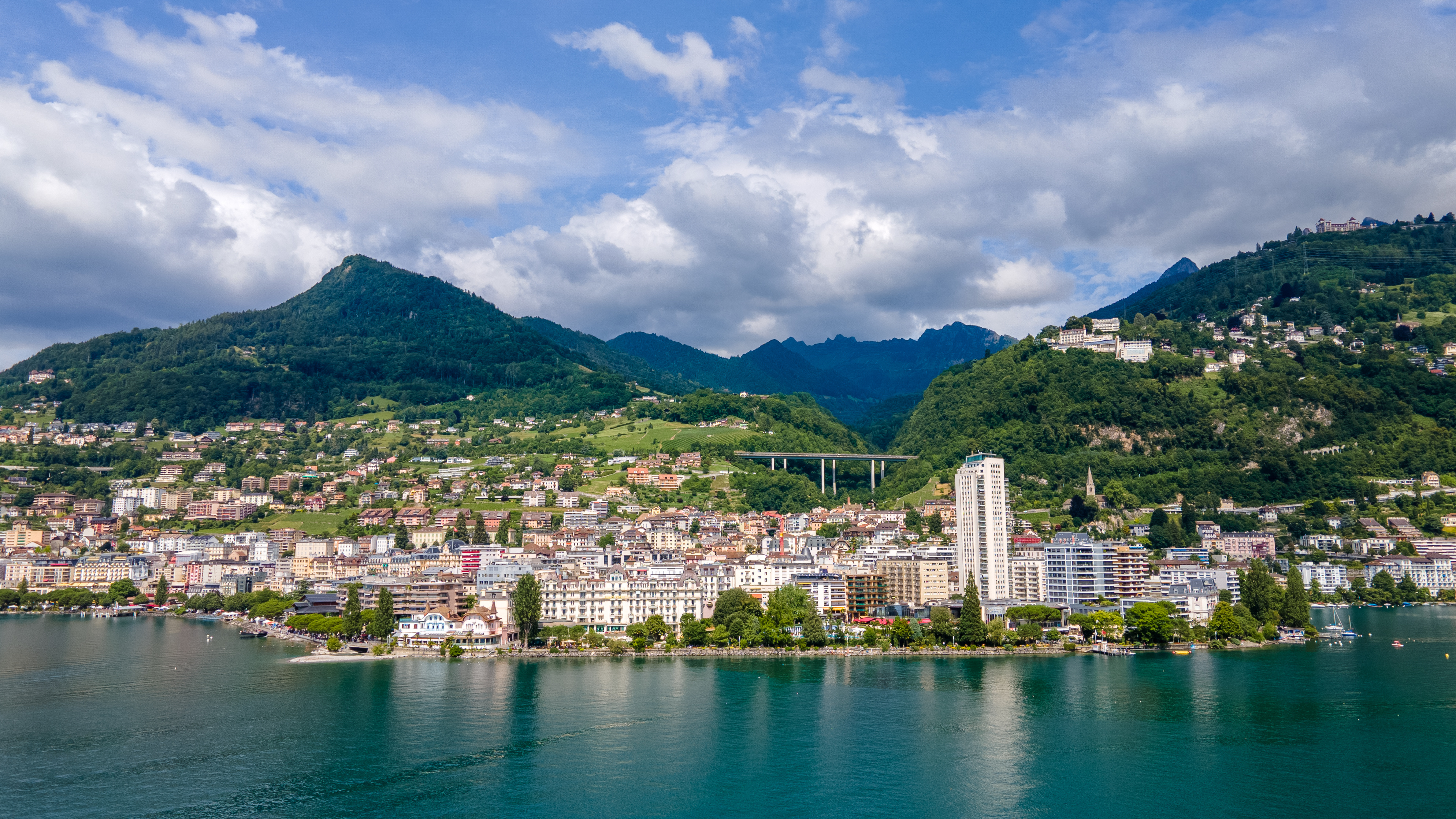 Urban cityscape by Lake Lugano, framed by towering mountains in the background in Montreux, Switzerland