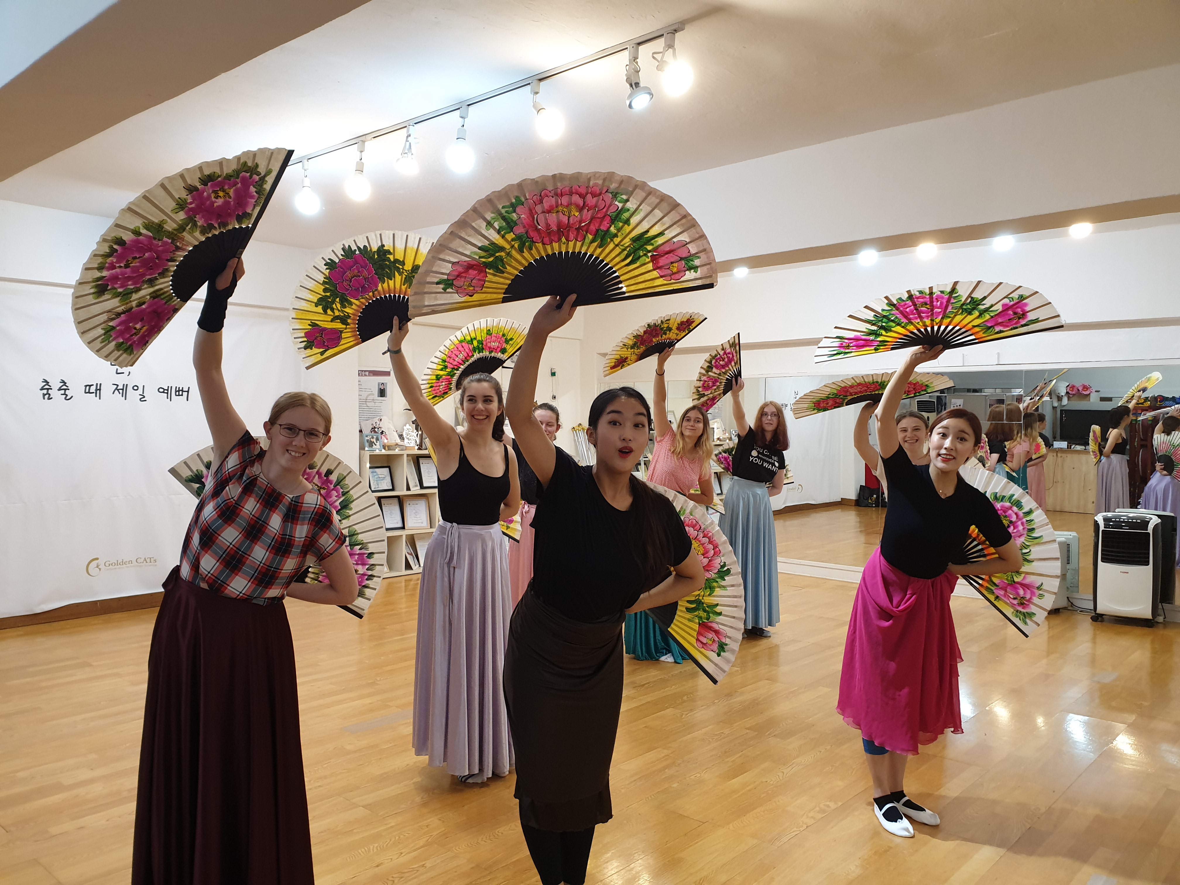 A group of students learning traditional Korean dancing