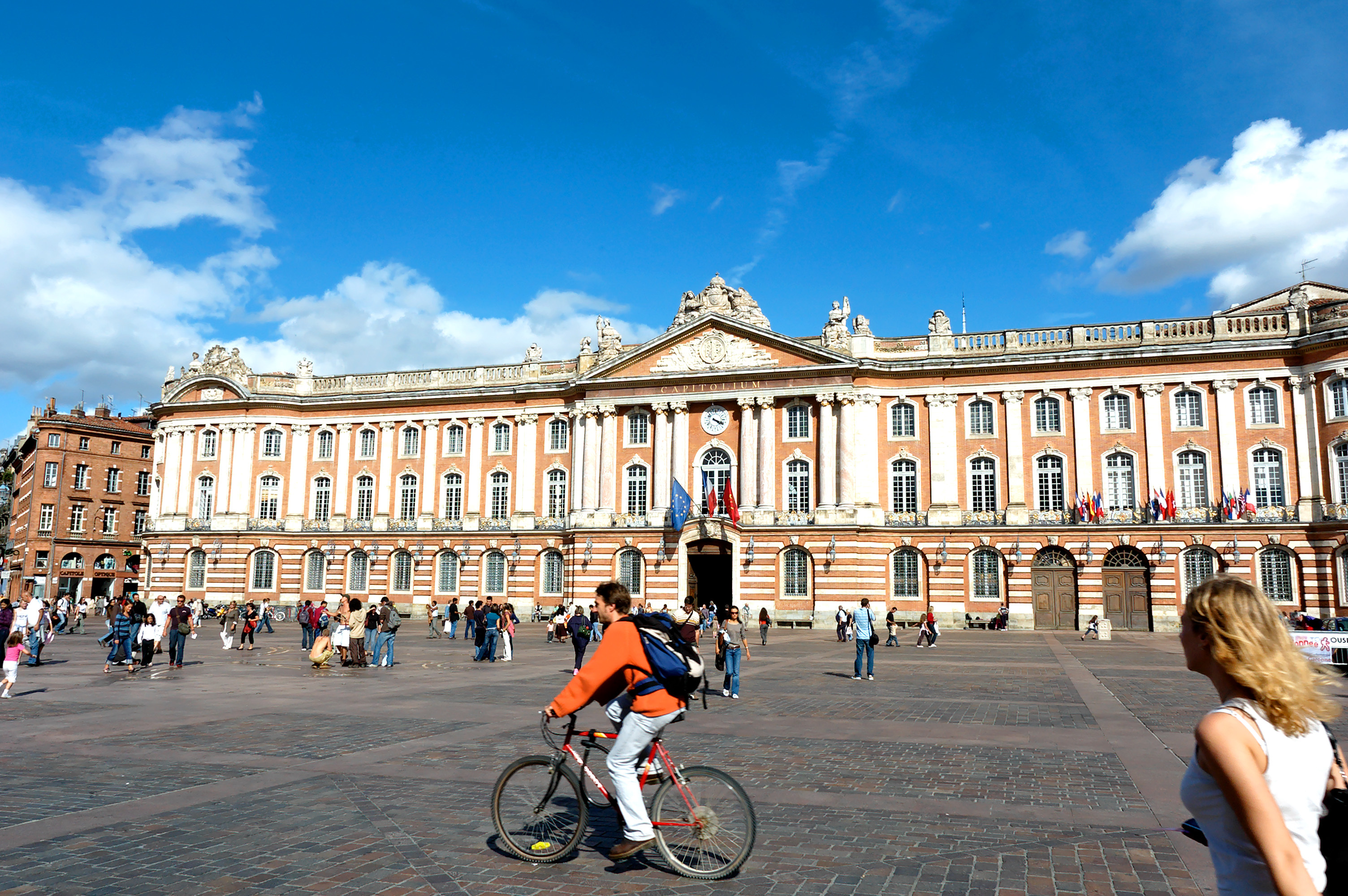La Place du Capitole in Toulouse with its grand square framed by elegant pink-brick buildings, including the iconic Capitole de Toulouse