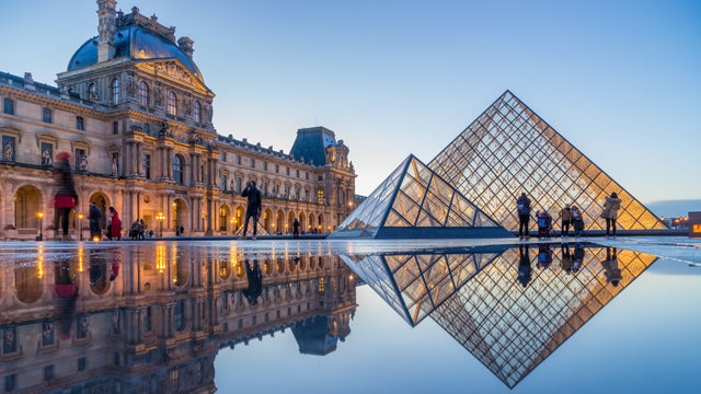 Louvre Museum with Louvre Pyramid at evening at sunset in Paris France