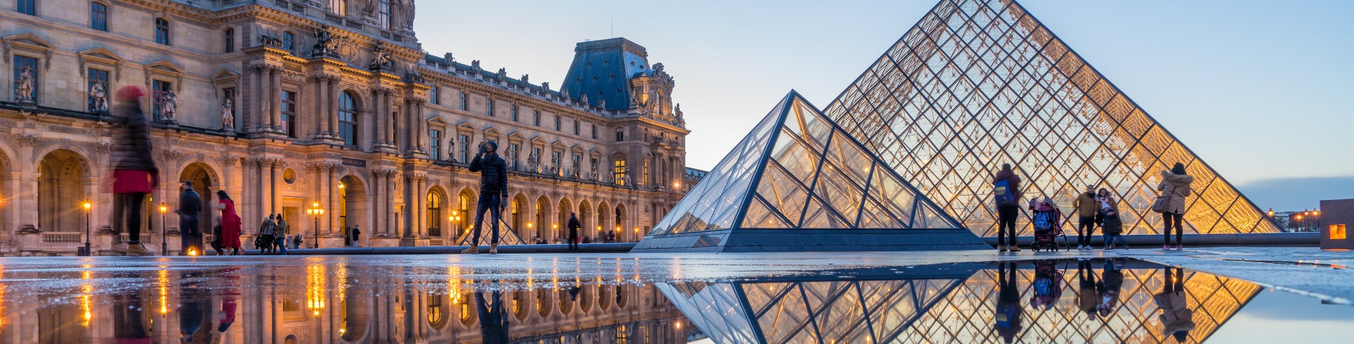 Louvre Museum with Louvre Pyramid at evening at sunset in Paris France