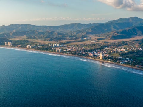 Aerial view of the beach with mountains in the background at Playa Jacó, Costa Rica