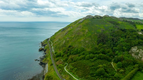 Steep cliff overlooking the ocean near Bray, Ireland, with rugged rock formations and waves crashing below