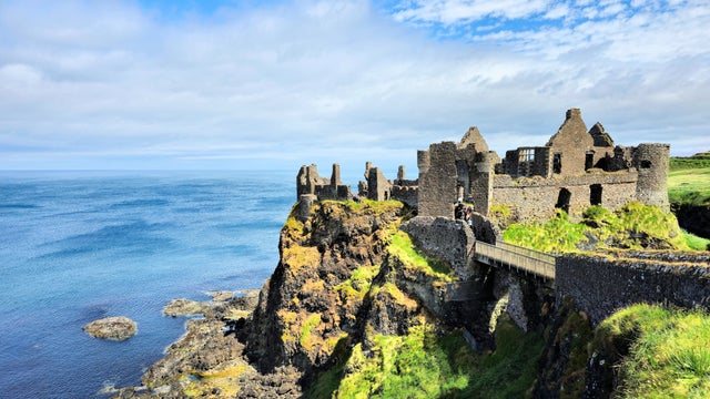 Ruined medieval Dunluce Castle perched dramatically on cliffs overlooking the North Atlantic Ocean in County Antrim, Northern Ireland