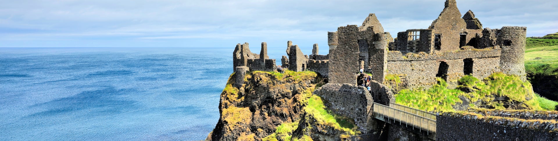 Ruined medieval Dunluce Castle perched dramatically on cliffs overlooking the North Atlantic Ocean in County Antrim, Northern Ireland