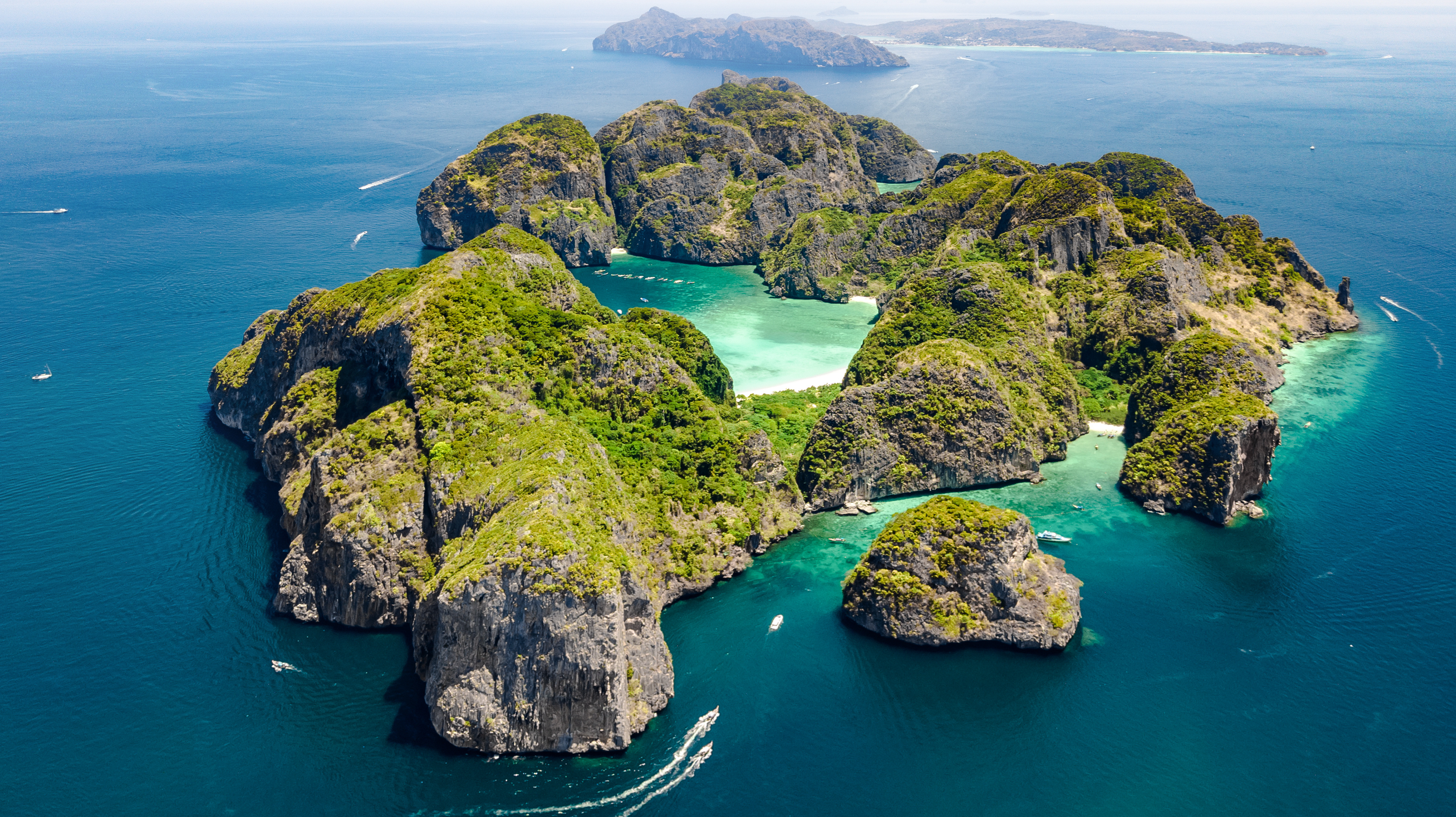 Aerial view of Phuket, Thailand, showcasing islands, coastline, and surrounding mountains