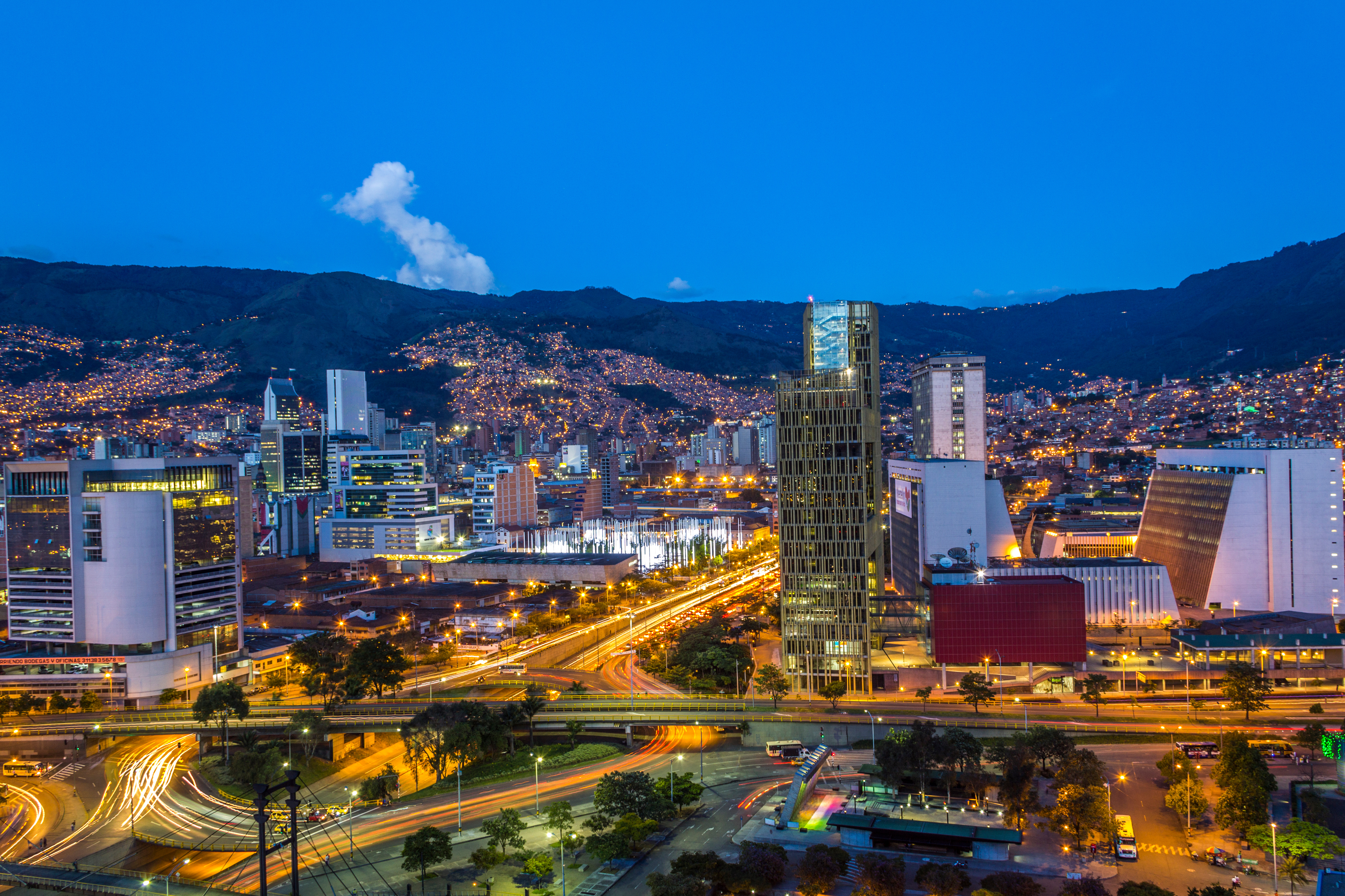 An aerial night view of Medellín City, Antioquia, Colombia, showing a dazzling urban landscape illuminated by countless city lights