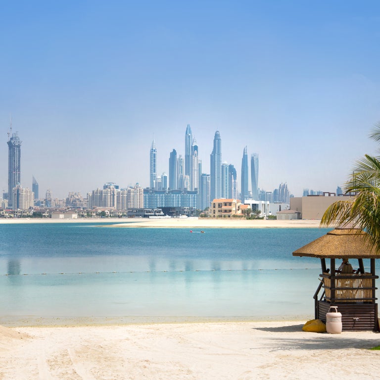 View from the beach in Dubai, United Arab Emirates, with modern skyscrapers lining the skyline in the background