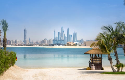 View from the beach in Dubai, United Arab Emirates, with modern skyscrapers lining the skyline in the background