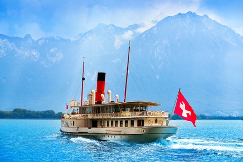Boat sailing on Lake Geneva near Montreux, Switzerland, with the Alps mountains in the background