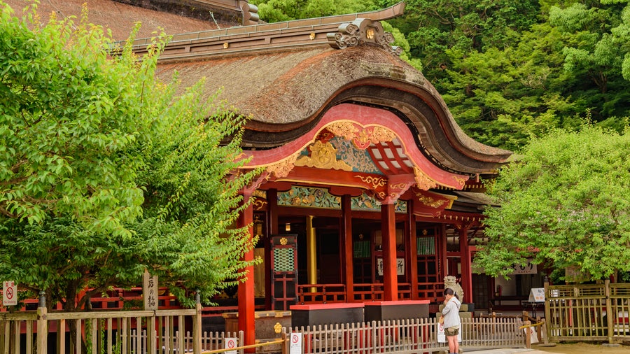 Dazaifu Tenmangu Shrine with a curved, ornate roof and vibrant red and gold details in in Fukuoka, Japan