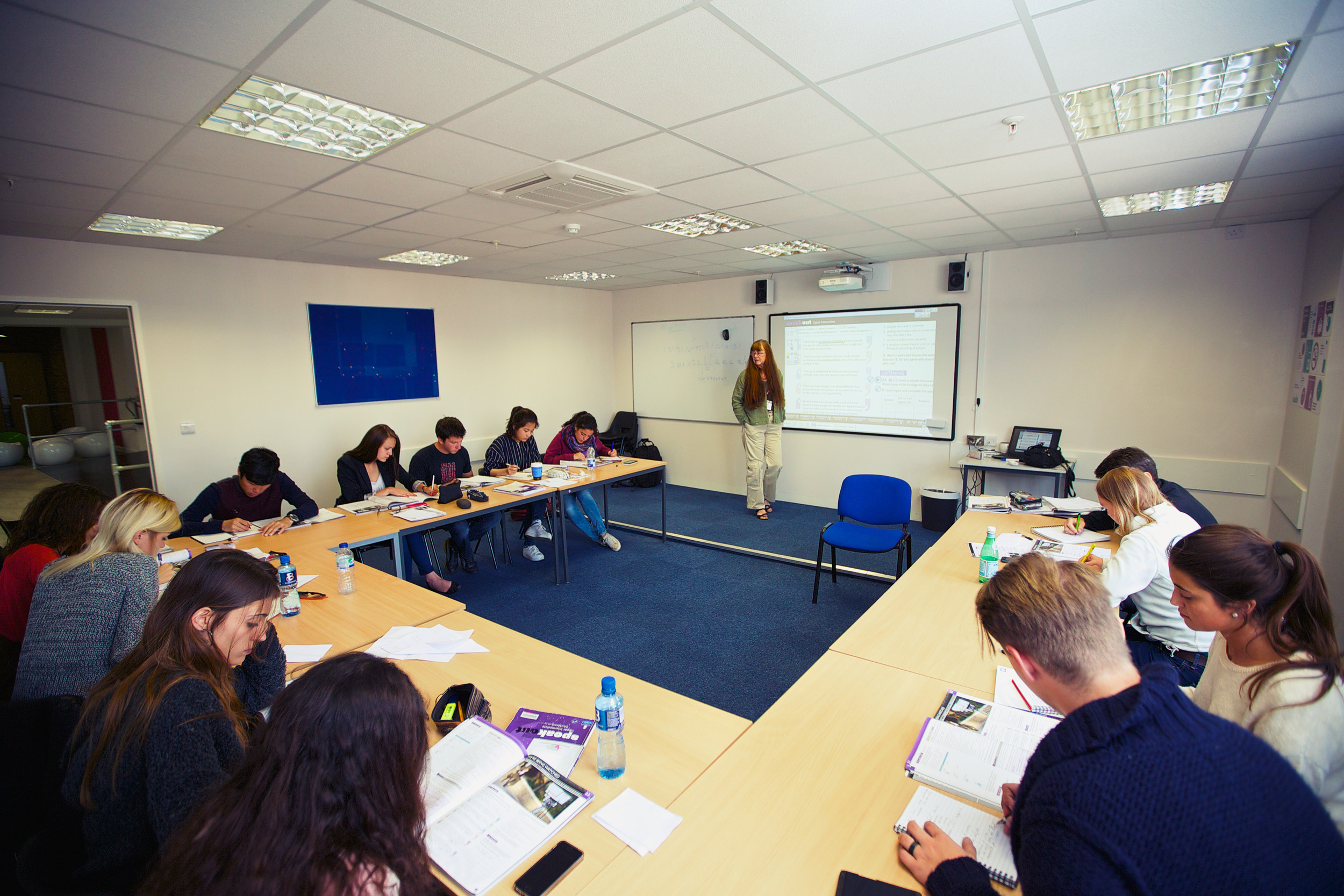 A teacher using the white board during a lesson
