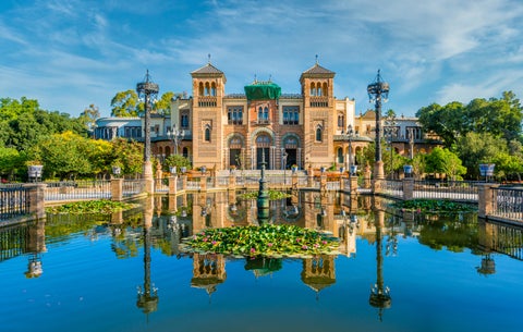 Museum of Popular Arts and Traditions in Seville, Andalusia, Spain, reflecting in a nearby fountain