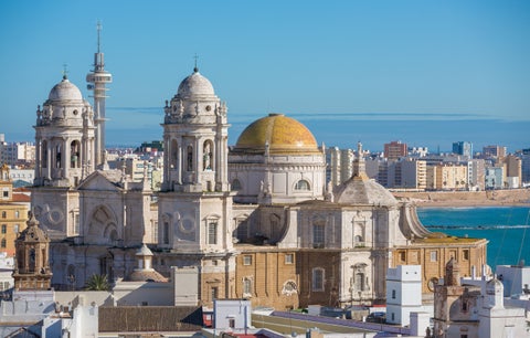 Aerial panoramic view of Cádiz, Spain, with morning light illuminating the old city rooftops and the Cathedral de Santa Cruz, seen from Torre Tavira