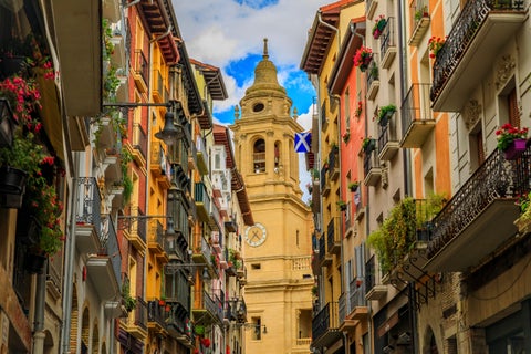 Street view in Pamplona, Spain, with historic buildings and the Catedral de Santa María la Real de Pamplona in the background