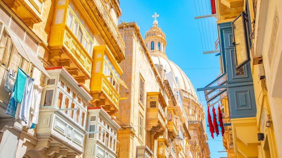 Narrow street with colourful balconies in Valletta old town, Malta